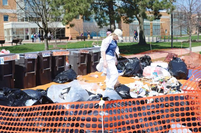 One person looks through garbage that is in on a tarp in the Union Oval at Bowling Green State University